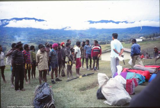 Porteurs papous au centre du village d'Illaga